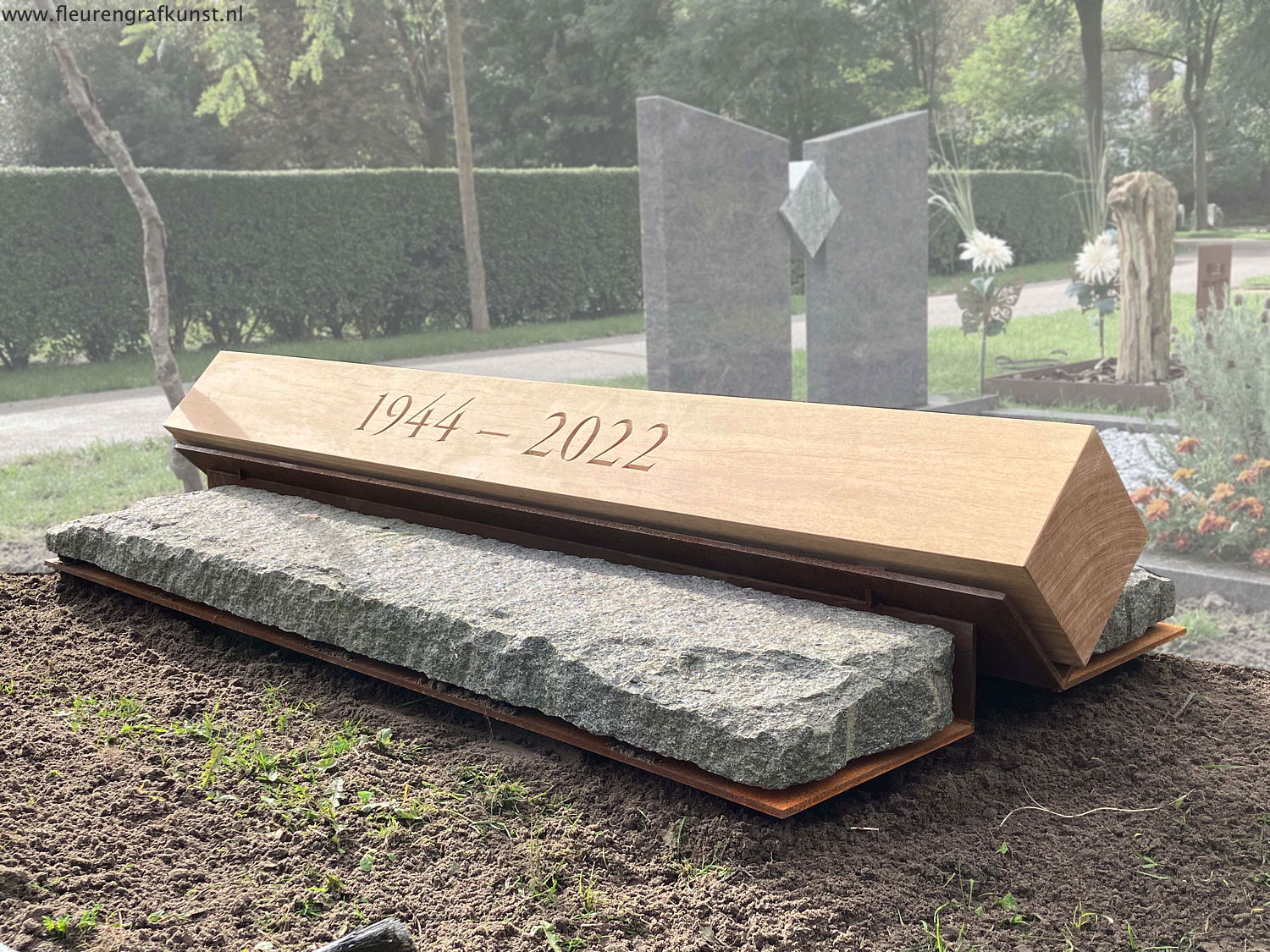 Monument met zware hardhouten balk op vleugels van cortenstaal ruwe graniet in Renesse